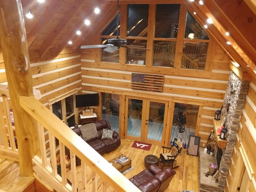 Photo of a great room taken from the upper level staircase showing the detail of a log and chink log home